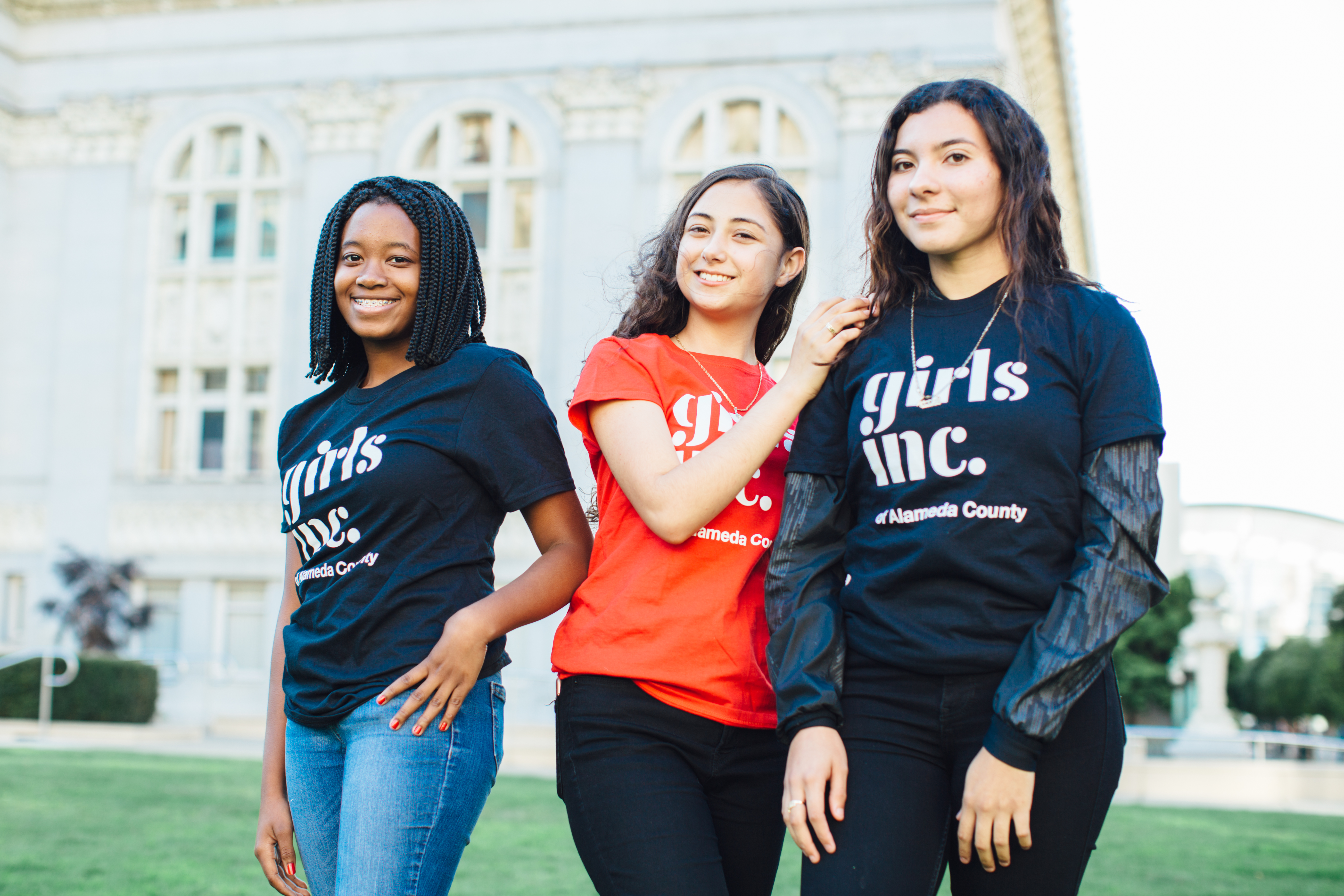 3 girls standing outside of a university